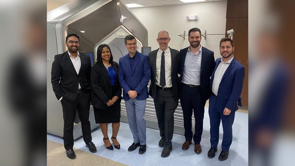 Lipson Cancer Institute leaders standing next to ETHOS machine
