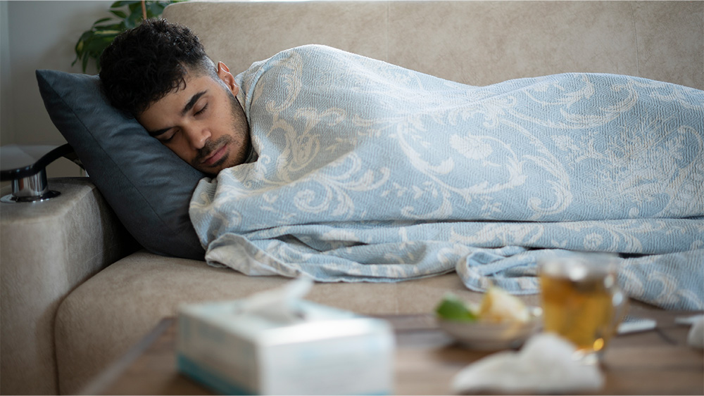 Man with body aches and chills under blanket
