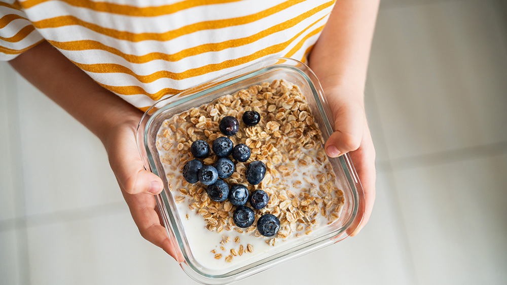 Person with oatmeal blueberries and milk