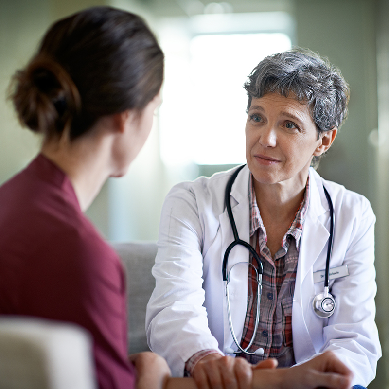 Shot of a compassionate doctor comforting a young woman in a hospital waiting room