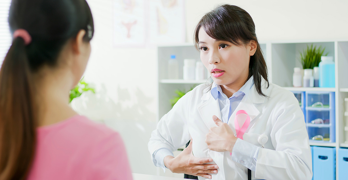 An Asian female doctor consults with a female patient about breast surgery in an office setting