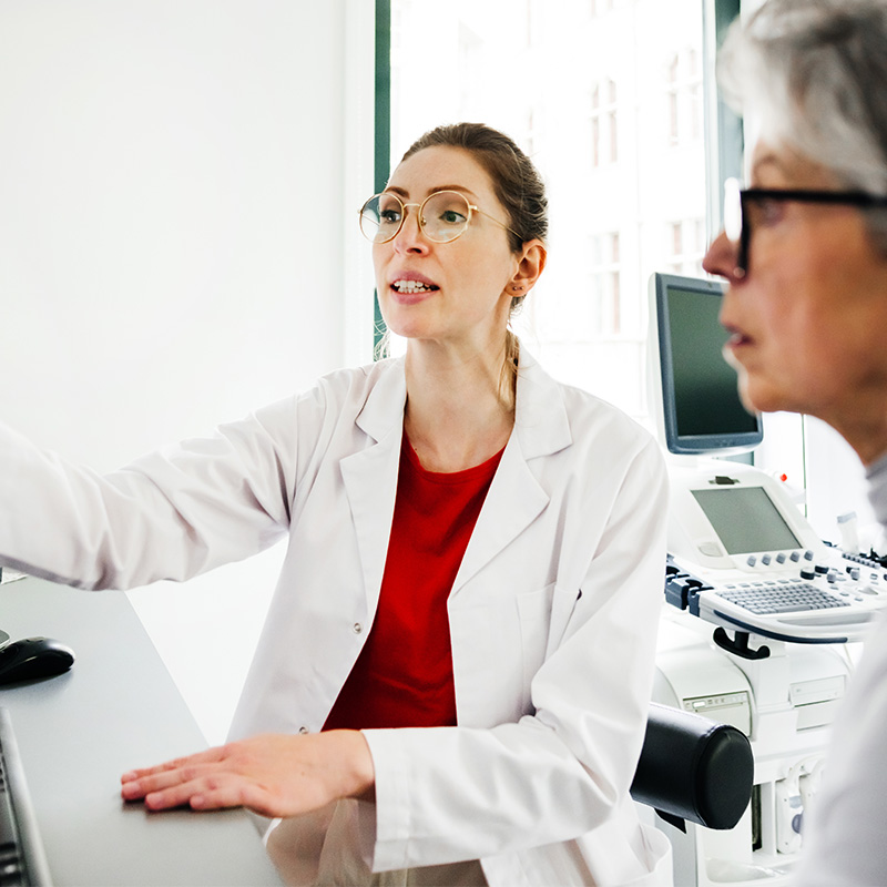 Female physician points at screen with older white female patient
