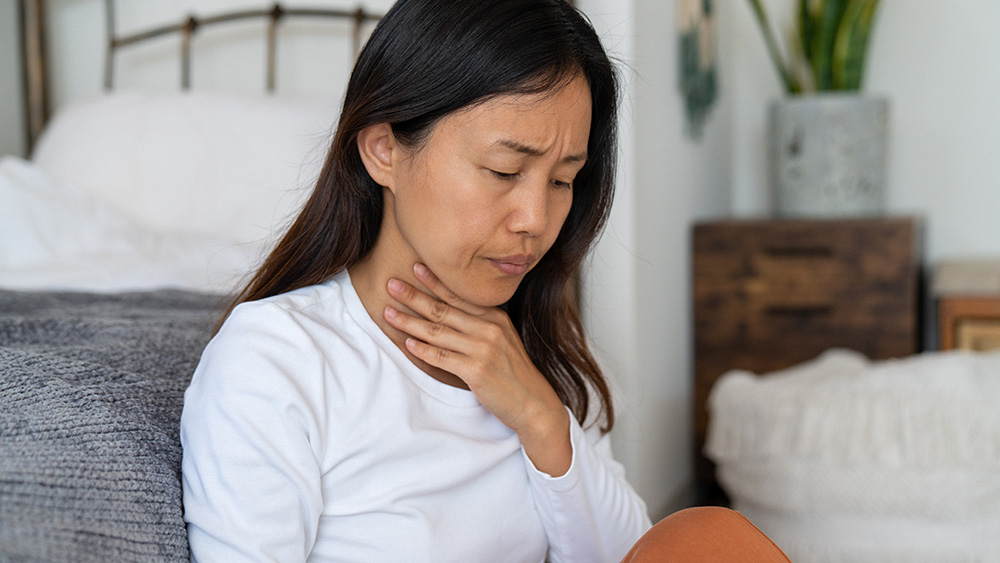 Woman holding sore throat