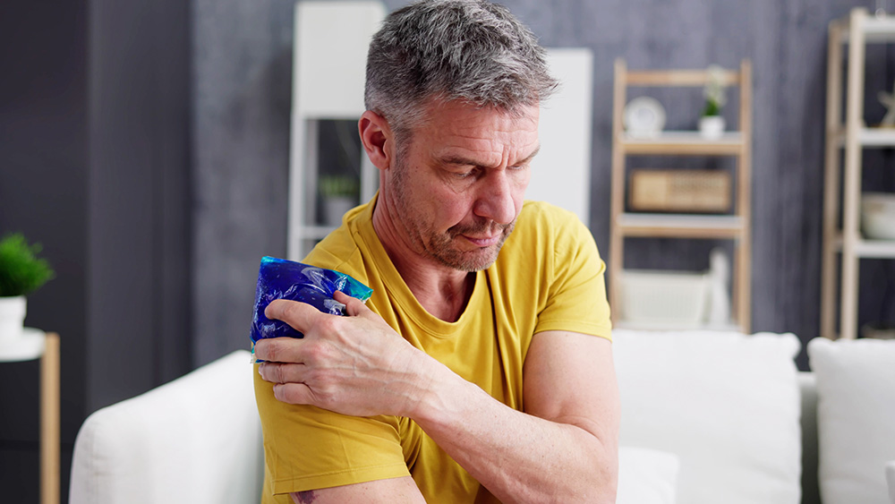 Man icing shoulder for bursitis pain