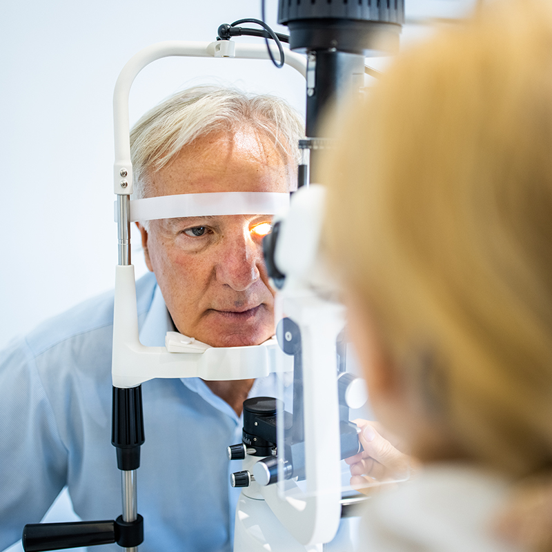 Senior man undergoing intraocular pressure exam at optometrist office