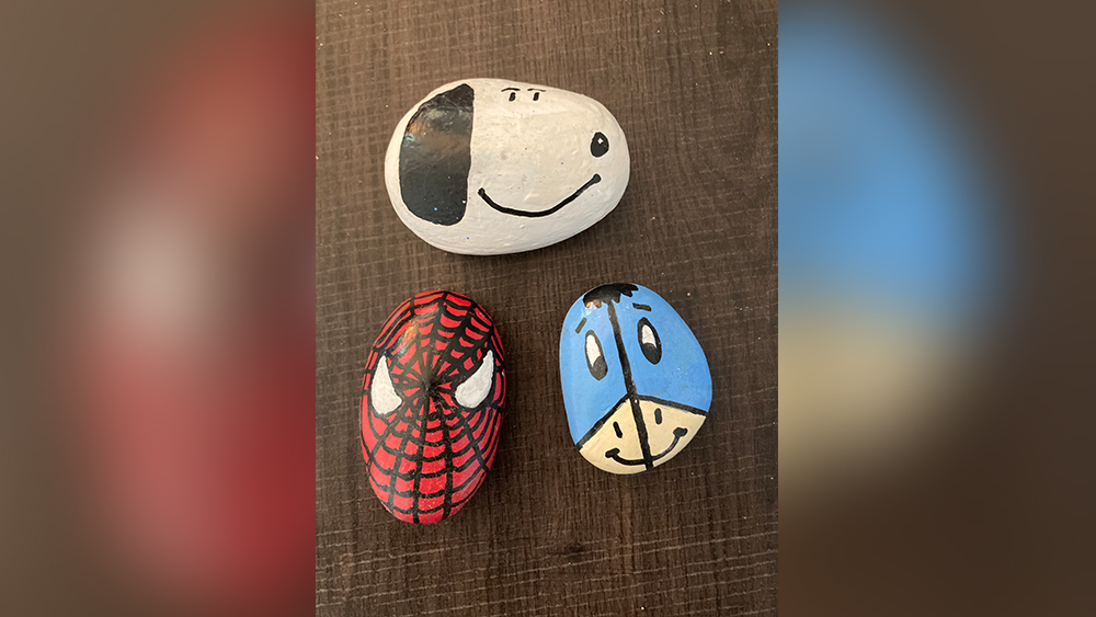 three hand painted rocks of snoopy spiderman and eeyore