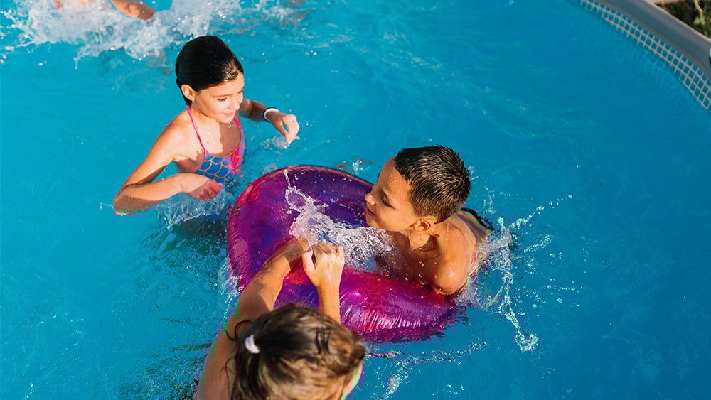 Group of children having fun playing and swimming in the pool