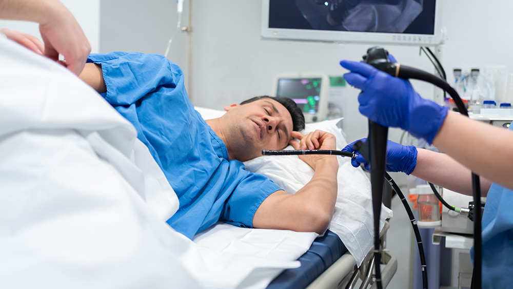 White male patient on table about to undergo colonoscopy