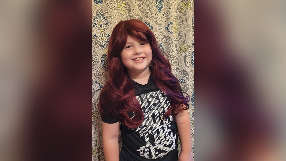 Young boy wearing red wig