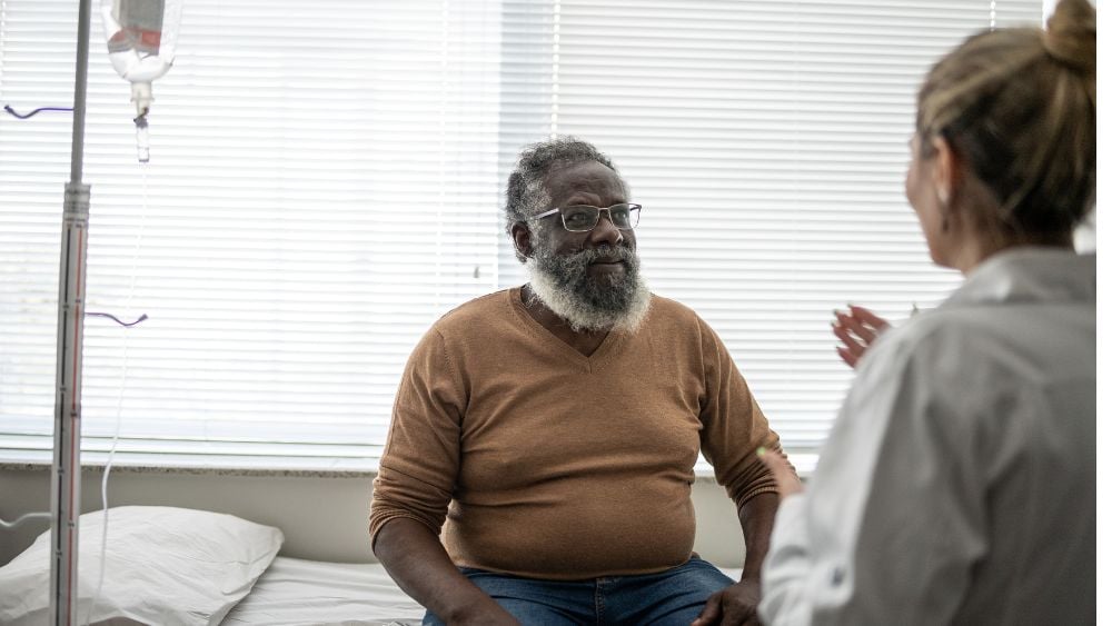 Older Black man with congestive heart failure talking with female physician