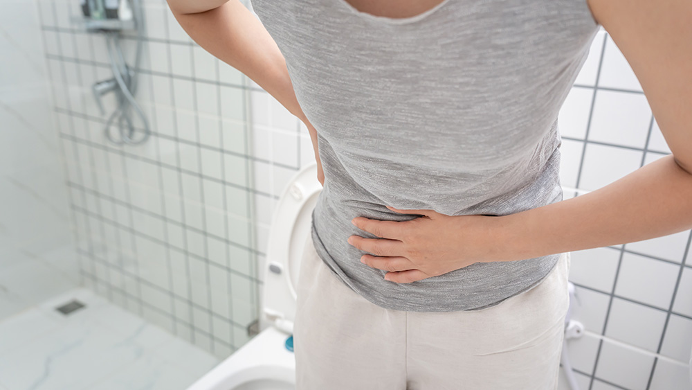 Woman in bathroom about to have diarrhea