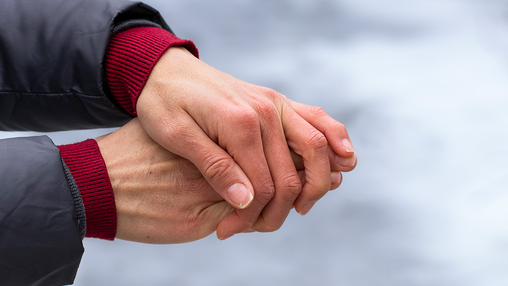 Women's hands with dry skin and red fingers in the cold in winter.