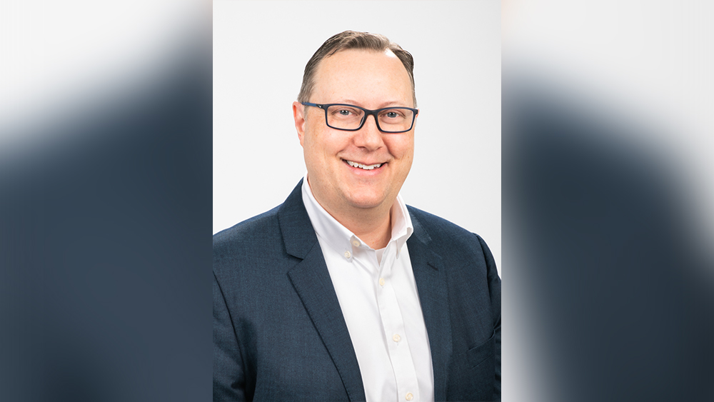 Smiling white man wearing glasses and suit jacket with button down dress shirt
