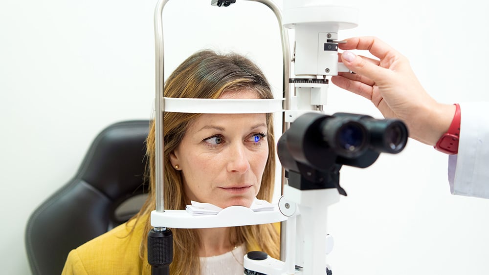 Woman having her eyes checked at ophthalmologist with professional equipment