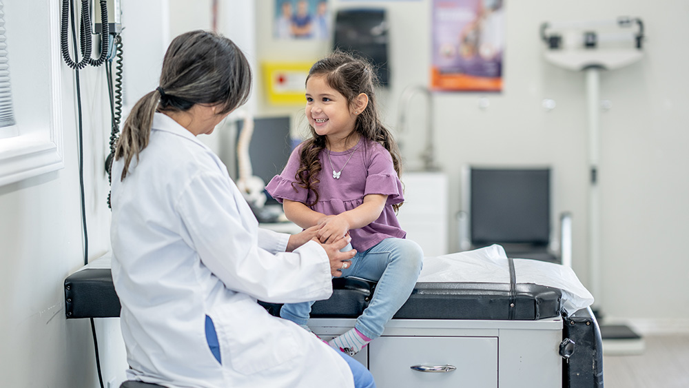 Female pediatrician talks with young female patient