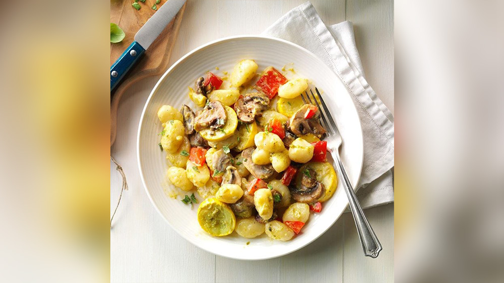 Gnocchi with garden vegetables in white bowl