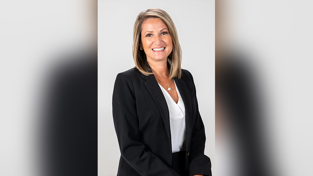 Woman in black suit and white blouse smiling at camera