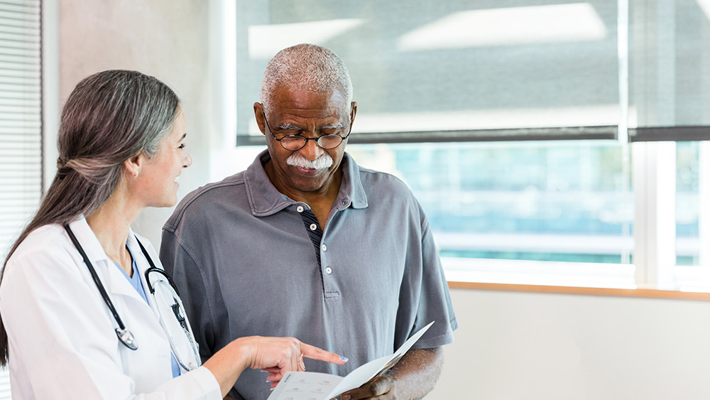 Female doctor talking with older male patient