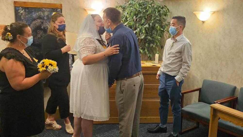 bride and groom with officiant best man and maid of honor wearing masks in hospital room wedding