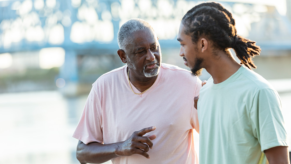 Older Black man talking with younger Black man