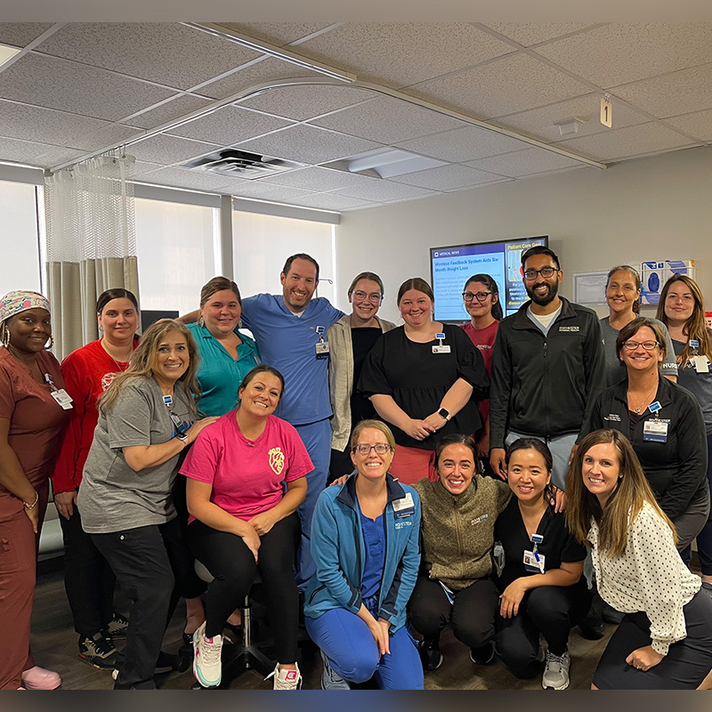 Team of medical professionals in two rows smiling at camera