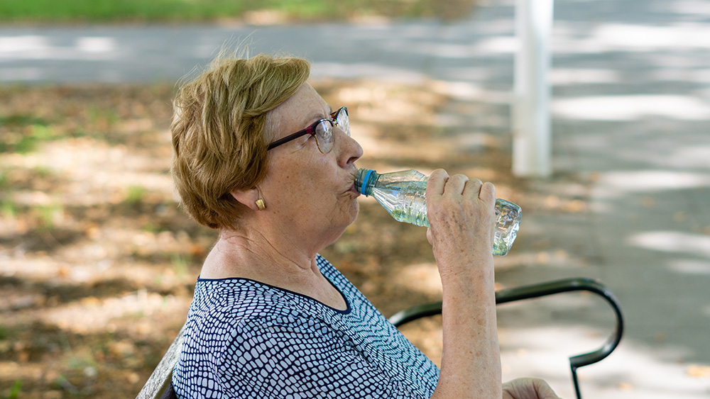 Older woman drinking water on hot day
