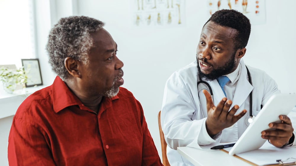 Older African American male patient listening to African American male cardiologist