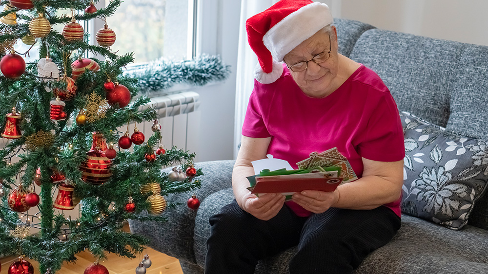 Elderly woman reading Christmas cards in nursing home