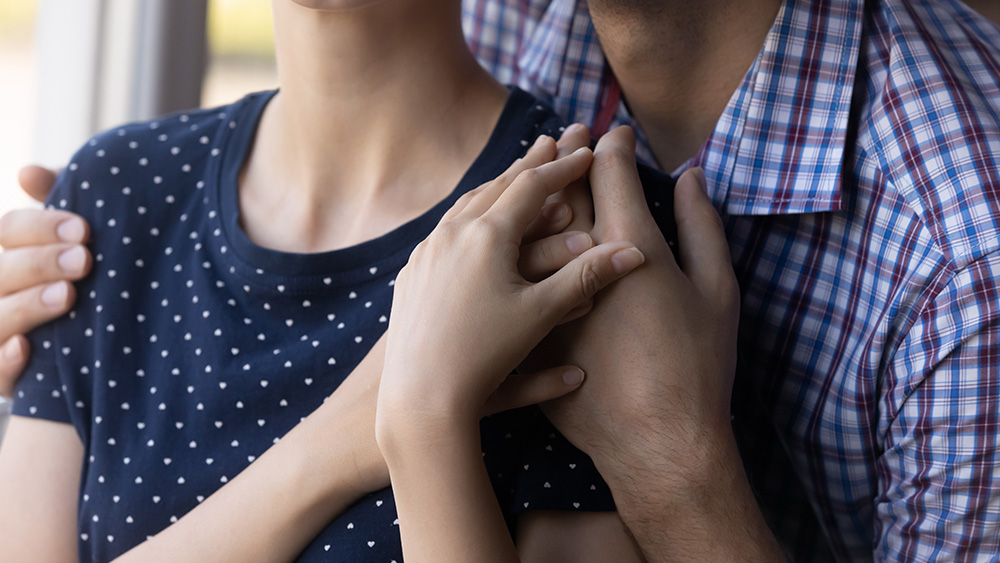 Man comforting woman with hug