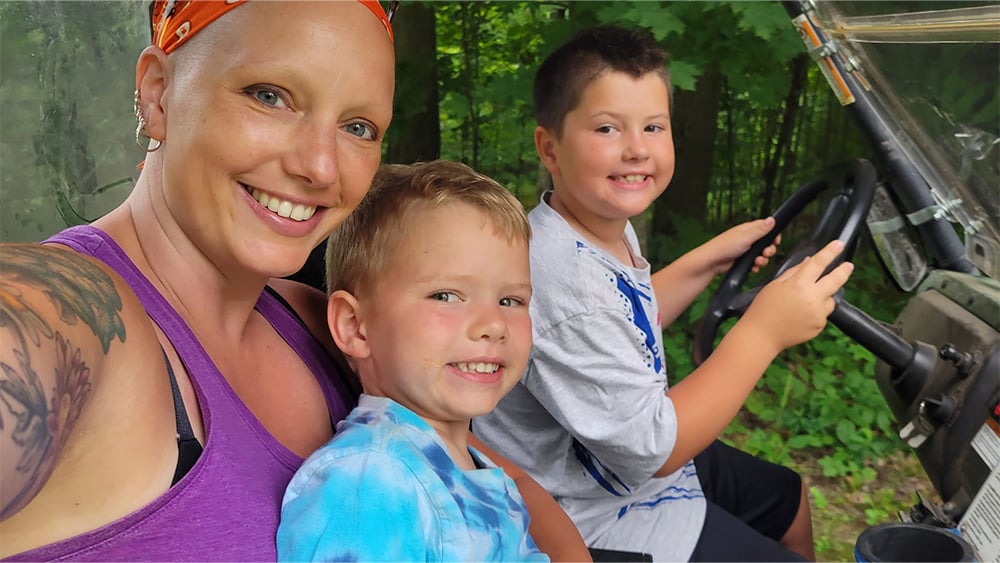 White woman with bandana with two young boys on UTV