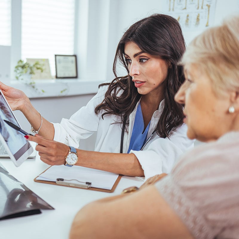 Lung cancer concept. Doctor explaining results of lung check up from x-ray scan chest on digital tablet screen to patient. The doctor is analyzing and clarifying images of the patient's lung X-rays.