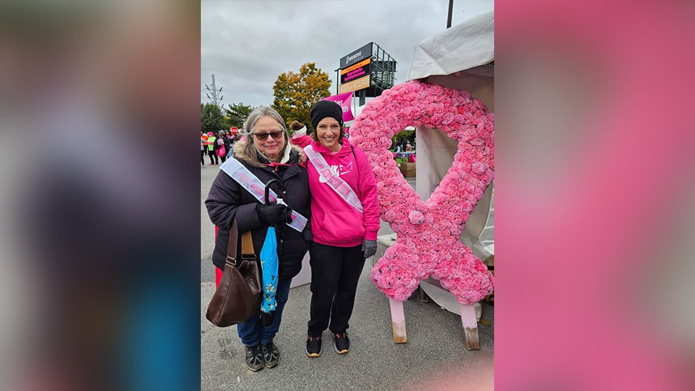 Mother and daughter smiling at breast cancer walk