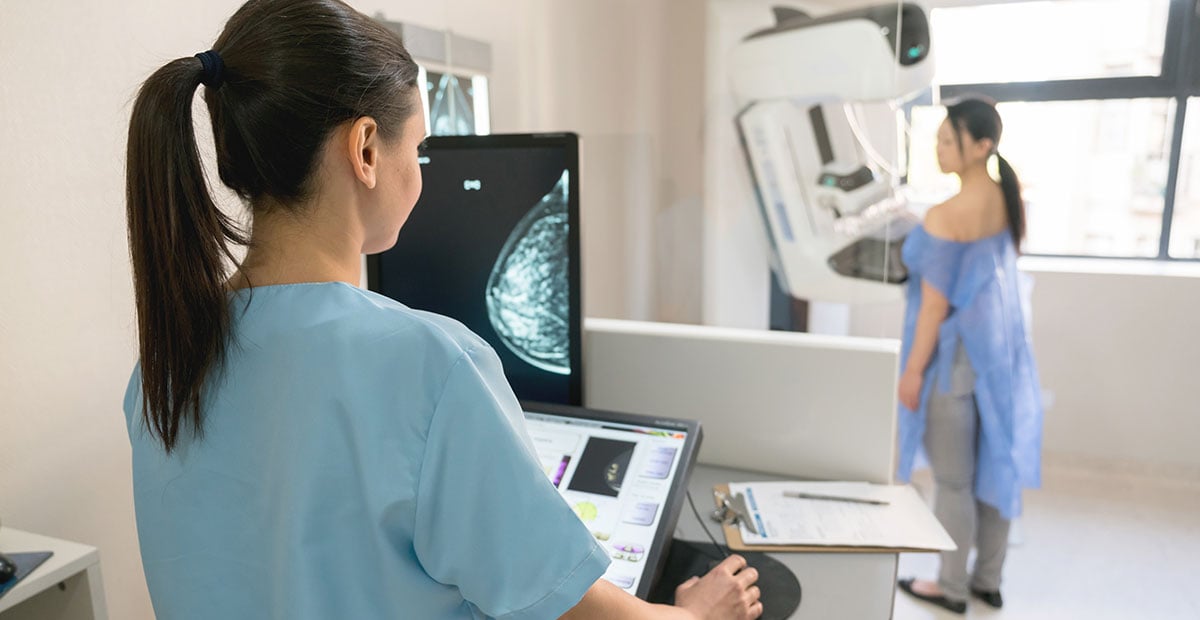 Unrecognizable nurse taking a mammogram exam to an adult patient at the hospital