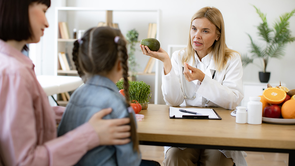 Doctor talks with child and mother about oral food challenge