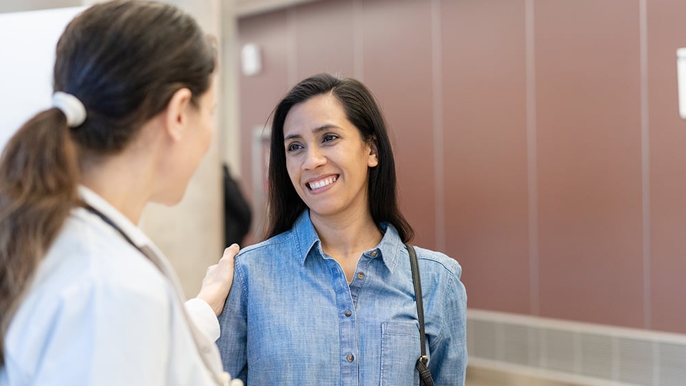 Female doctor talking with an female patient in the hospital hallway