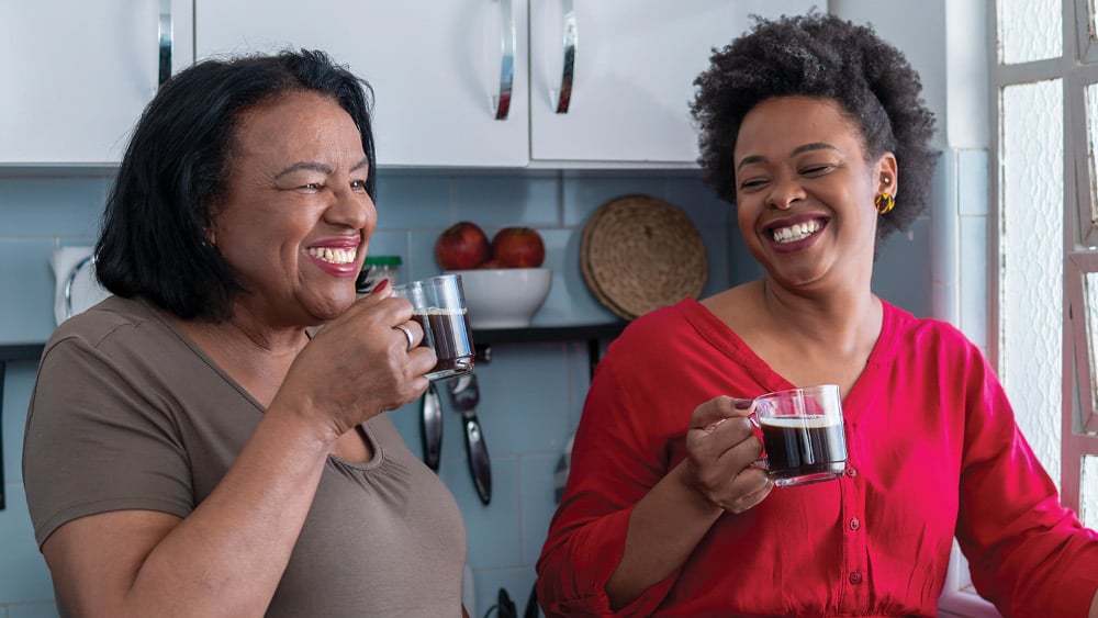 Two middle aged African American women drinking coffee