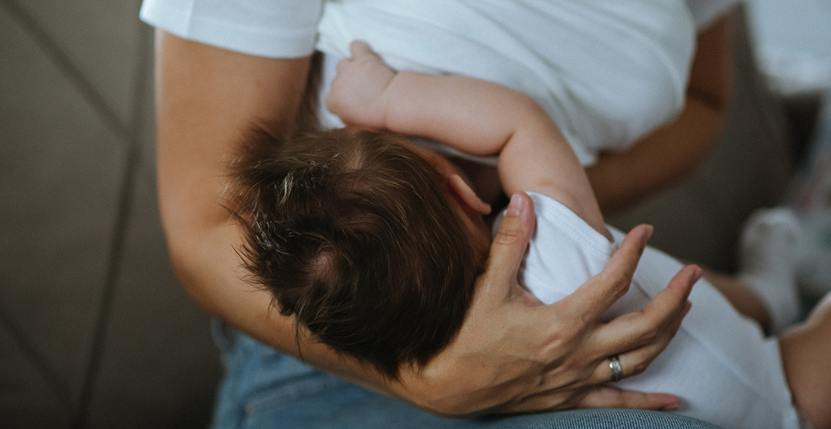 Young mother breastfeeding her baby boy. Close-up of a young single mother breastfeeding her newborn baby.