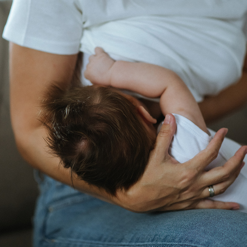 Young mother breastfeeding her baby boy. Close-up of a young single mother breastfeeding her newborn baby.