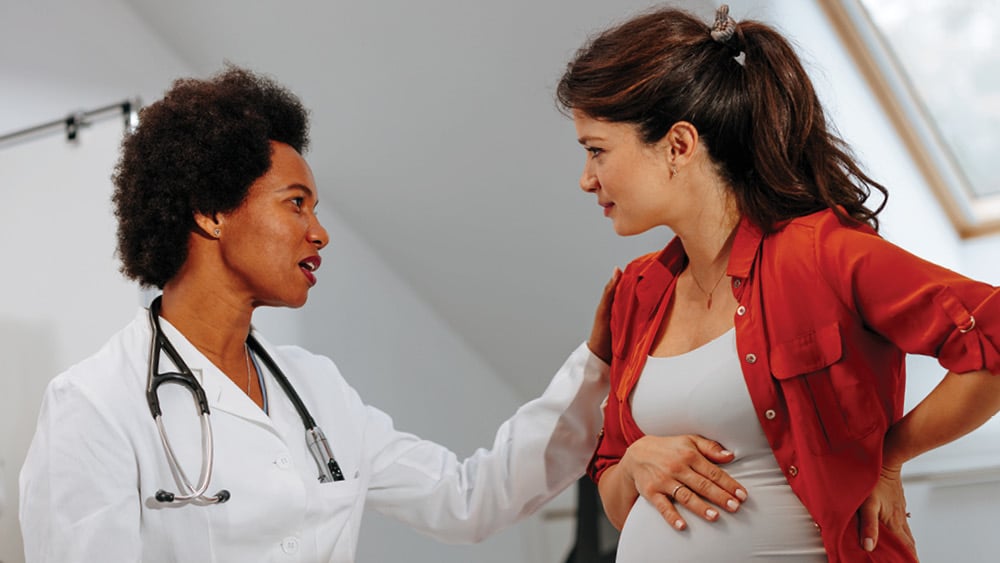 Female health provider talking with female pregnant patient