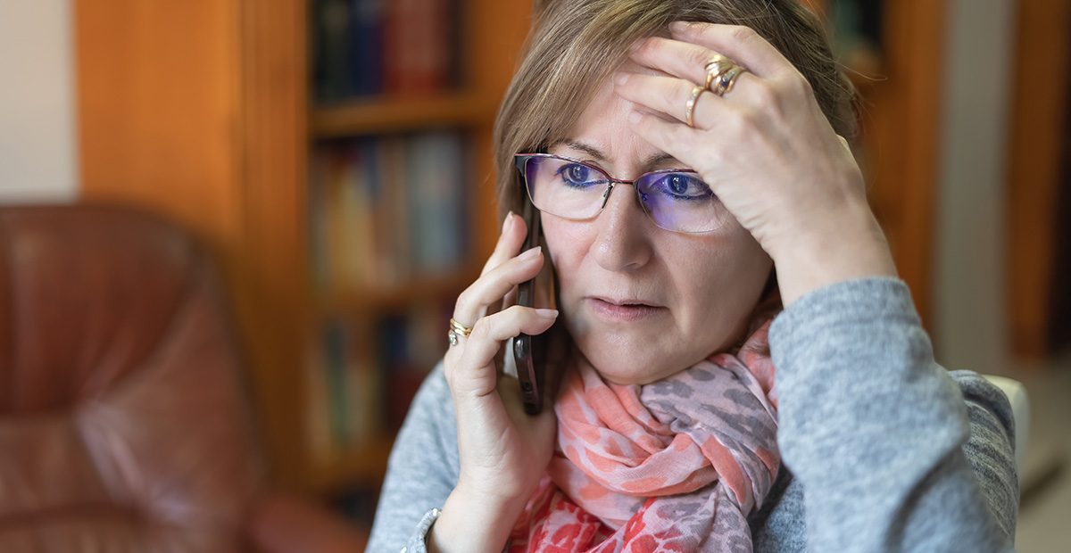 White woman talking on the phone and receiving bad news with a worried face.