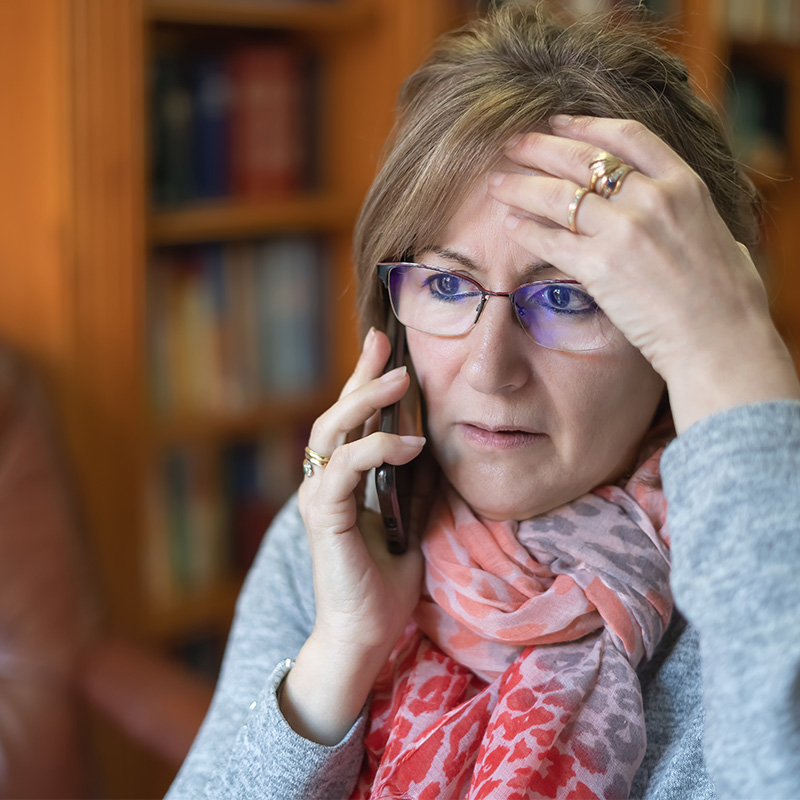 White woman talking on the phone and receiving bad news with a worried face.