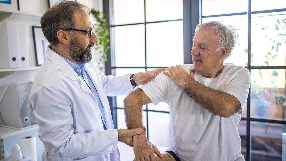 physician checking where the pain starts on patient's arm