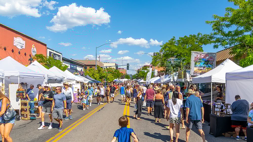 Three young women having fun, laughing, and bonding on the beach at night, radiating joy and excitement in a diverse group of friends enjoying the vibrant summer nightlife
