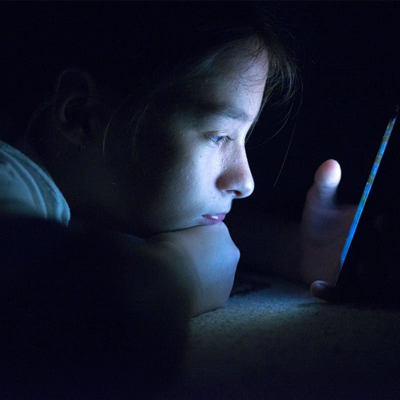 Teenager sending email from smart phone in her bed, Typing text message on smartphone. young cell phone addict teen awake at night in bed using smartphone for chatting