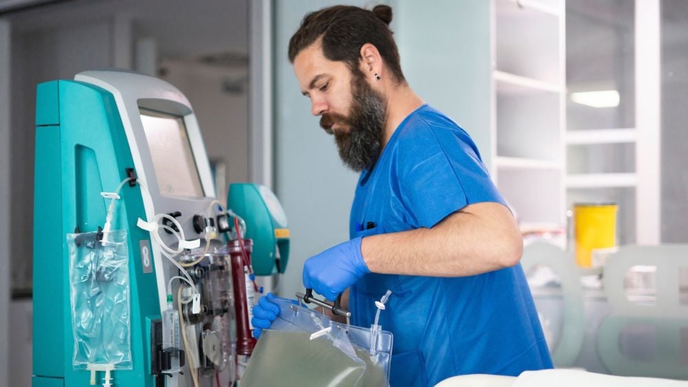 Male nurse setting up hemodialysis machine in hospital