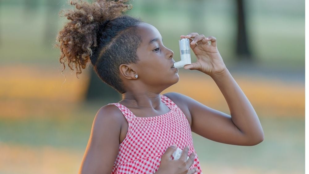 Child using inhaler for asthma