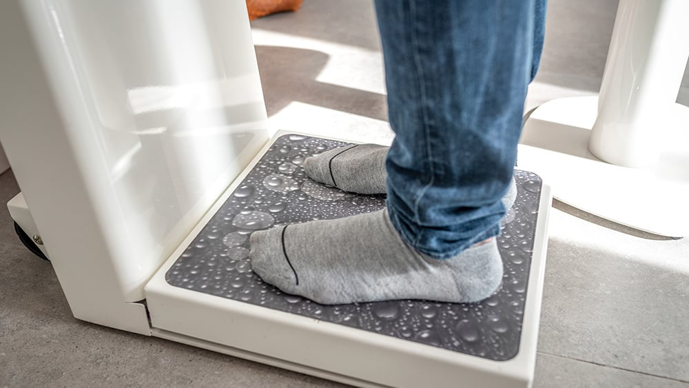 Male on weight scale on floor background