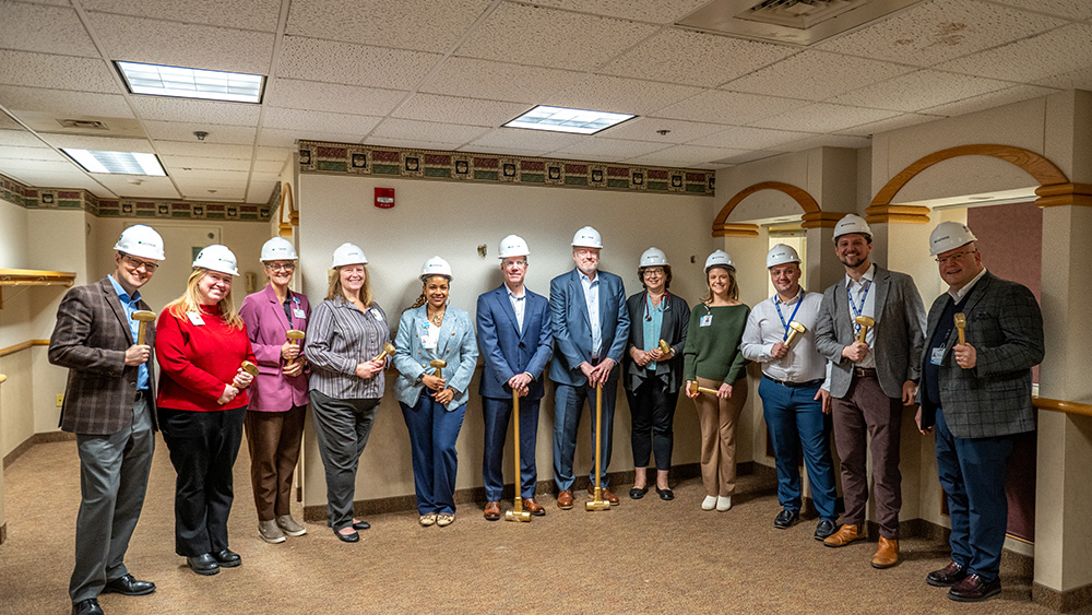 Executives with Rochester Regional Health pose with golden sledgehammers
