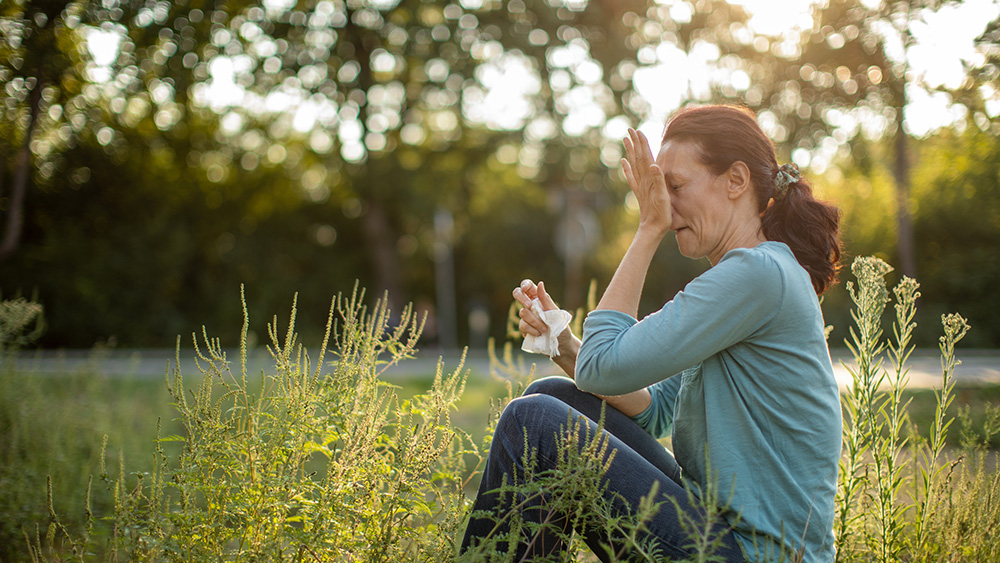 Woman with allergies in field