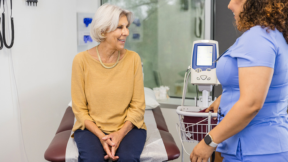 Senior woman smiles at female healthcare provider in office setting